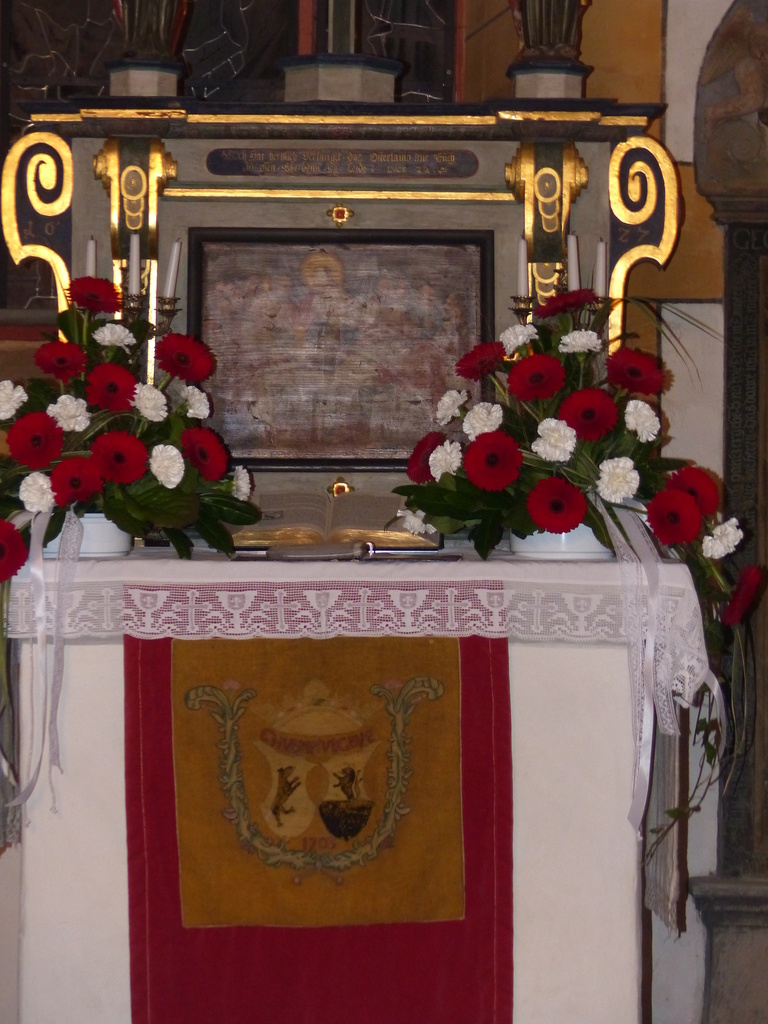 Der gedeckte Altar mit dem selten genutzten roten Parament mit dem Wappen derer von Bibra
